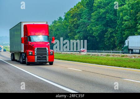 Horizontale Aufnahme eines modernen roten Sattelanhängers auf der Autobahn. Stockfoto