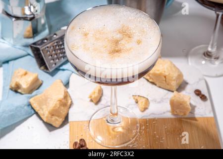 Parmesan Cheese Espresso Martini Cocktail, käsiges Schlagsahne Kaffeegetränk in martini Glas mit geriebenem Parmesan Stockfoto