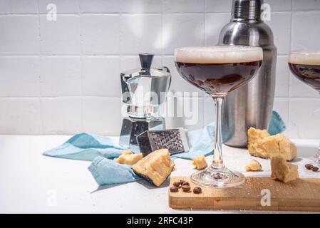 Parmesan Cheese Espresso Martini Cocktail, käsiges Schlagsahne Kaffeegetränk in martini Glas mit geriebenem Parmesan Stockfoto