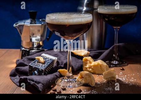 Parmesan Cheese Espresso Martini Cocktail, käsiges Schlagsahne Kaffeegetränk in martini Glas mit geriebenem Parmesan Stockfoto