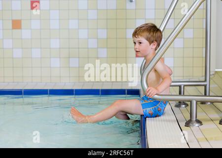 Bornheim, Deutschland. 02. Aug. 2023. Thema: Ein Vorschulkind sitzt am Rand des Pools in einem öffentlichen Bad. Kredit: dpa/Alamy Live News Stockfoto