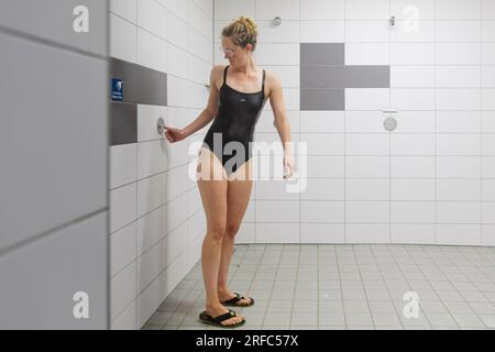Bornheim, Deutschland. 02. Aug. 2023. Thema: Frau duscht in einem öffentlichen Badehaus. Kredit: dpa/Alamy Live News Stockfoto