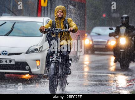 Fotoshows: Nasser August harte Fahrt ohne Visier auf dem E-Bike nasses Wetter in London, da schwere Schauer und Stürme die Hauptstadt 2.8.23 heimsuchten Pi Stockfoto