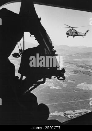 VIETNAM - 1965 - Helikopter-Schütze während des Kampfes in Vietnam gegen die kommunistischen Kräfte Nordvietnams in einem nicht identifizierten Gebiet Südvietnams - Foto Stockfoto