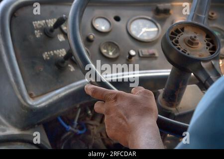 Die Hände des Fahrers am Lenkrad eines alten Busses. Indischer Transport Stockfoto