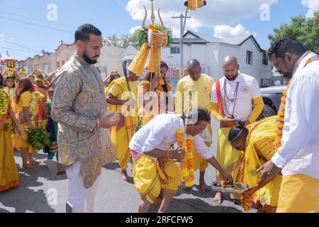 Eine pandita-Präfektin marschiert von ihrem Tempel zum Ort des Thimithi-Feuerspaziergangs mit einer kunstvoll verzierten Statue einer Gottheit. In Richmond Hill, Queens. Stockfoto