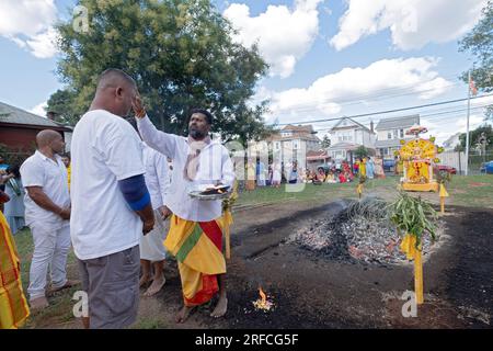 Bevor das Feuer zu Fuß geht, malt ein Priester auf dem spirituellen Gelände von Arya eine Tilaka auf die Stirn eines gläubigen Gläubigen. In Jamaika, Queens, New York. Stockfoto