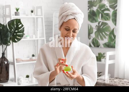 Reife Frau, die Gesichtscreme im Bad aufträgt Stockfoto
