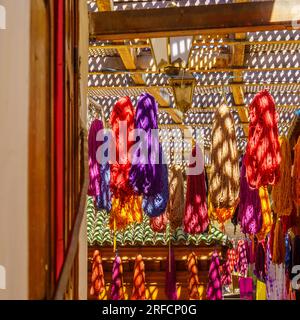 Blick auf farbenfrohe Stoffe und schattige Muster in der alten Medina von Fez, Marokko Stockfoto