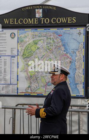 königlicher Marineoffizier steht neben dem Welcome to cowes Kartenbrett während der jährlichen cowes Week Regatta auf der Insel wight uk Stockfoto