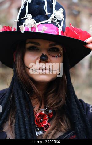 Eine Frau im Bild von Baron Saturday posiert vor dem Hintergrund eines alten Backsteingebäudes. Das Model trägt ein Korsett, eine Strickjacke und ein Top H. Stockfoto