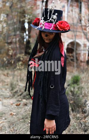 Eine Frau im Bild von Baron Saturday posiert vor dem Hintergrund eines alten Backsteingebäudes. Das Modell trägt ein Korsett, eine Strickjacke und einen Stockfoto