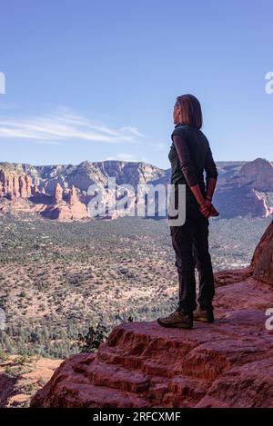 Eine Frau genießt die weitläufige Aussicht über das Tal unten mit Blick auf Sedona in Arizona, USA Stockfoto