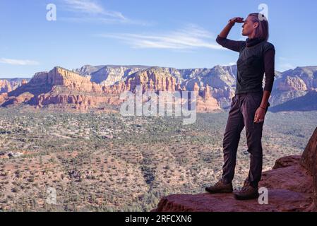 Eine Frau genießt die weitläufige Aussicht über das Tal unten mit Blick auf Sedona in Arizona, USA Stockfoto