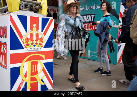 Besucher der Hauptstadt und Londoner gehen am Piccadilly Circus im West End am 25. Juli 2023 in London, England, vorbei an touristischen Souvenirläden. Stockfoto