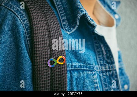 Kleiner Junge mit Autismus-Unendlichkeits-Regenbogen-Symbol. Welttag des Autismus-Bewusstseins, Bewegung der Autismusrechte, Neurodiversität, autistische Akzeptanzbewegung Stockfoto