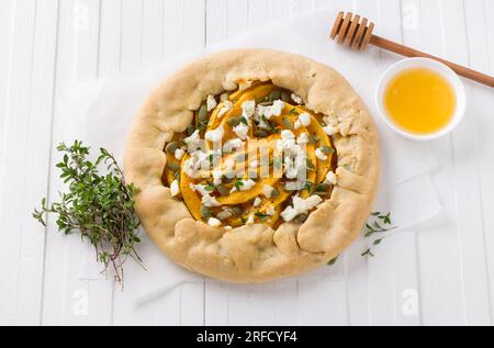 Hausgemachte Galette mit Kürbis, Fetakäse, Honig, Kürbiskernen und Thymian auf weißem Hintergrund, Draufsicht. Stockfoto