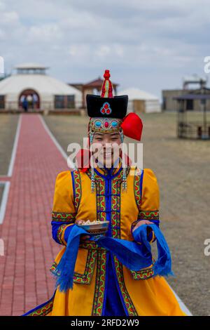 Eine junge mongolische Frau in traditioneller Kleidung in der Gobi Mirage Lodge in der Wüste Gobi, südliche Mongolei. Stockfoto