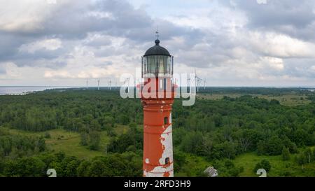 Ein Drohnenfoto eines Leuchtturms mit Windturbinen im Hintergrund Stockfoto