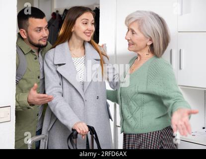 Ältere Frau, die das Paar zu Hause begrüßt Stockfoto