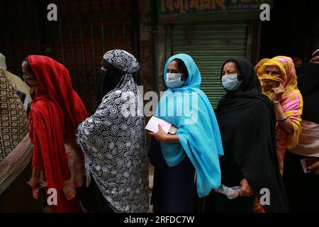 DHAKA, BANGLADESCH -7. SEPTEMBER 2021: Frauen in Schlange, um während einer Massenimpfkampagne in einem Impfzentrum in Dhaka, Bangladesch am 7. September 2021 eine Impfung mit dem COVID19-Impfstoff zu erhalten. Stockfoto