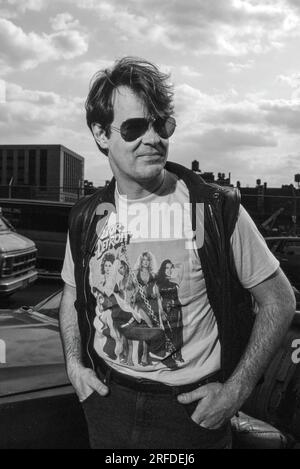 Kommedian/Schauspieler Dan Aykroyd am Drehort 1982. Bernard Gotfryd Foto. Daniel Edward Aykroyd ist ein kanadischer Schauspieler, Komiker, Drehbuchautor, Produzent und Musiker. Aykroyd war Autor und ursprüngliches Mitglied der „Not Ready for Prime Time Players“-Besetzung der NBC-Sketch-Comedy-Serie Saturday Night Live von ihrer Gründung im Jahr 1975 bis zu seiner Abreise im Jahr 1979. Während seiner Amtszeit bei SNL erschien er in einer wiederkehrenden Reihe von Skizzen, insbesondere zu den Coneheads und den Blues Brothers. Stockfoto