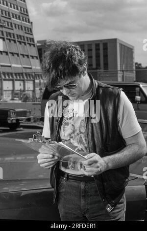 Kommedian/Schauspieler Dan Aykroyd am Drehort 1982. Bernard Gotfryd Foto. Daniel Edward Aykroyd ist ein kanadischer Schauspieler, Komiker, Drehbuchautor, Produzent und Musiker. Aykroyd war Autor und ursprüngliches Mitglied der „Not Ready for Prime Time Players“-Besetzung der NBC-Sketch-Comedy-Serie Saturday Night Live von ihrer Gründung im Jahr 1975 bis zu seiner Abreise im Jahr 1979. Während seiner Amtszeit bei SNL erschien er in einer wiederkehrenden Reihe von Skizzen, insbesondere zu den Coneheads und den Blues Brothers. Stockfoto