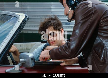 Kommedian/Schauspieler Dan Aykroyd am Drehort 1982. Bernard Gotfryd Foto. Daniel Edward Aykroyd ist ein kanadischer Schauspieler, Komiker, Drehbuchautor, Produzent und Musiker. Aykroyd war Autor und ursprüngliches Mitglied der „Not Ready for Prime Time Players“-Besetzung der NBC-Sketch-Comedy-Serie Saturday Night Live von ihrer Gründung im Jahr 1975 bis zu seiner Abreise im Jahr 1979. Während seiner Amtszeit bei SNL erschien er in einer wiederkehrenden Reihe von Skizzen, insbesondere zu den Coneheads und den Blues Brothers. Stockfoto