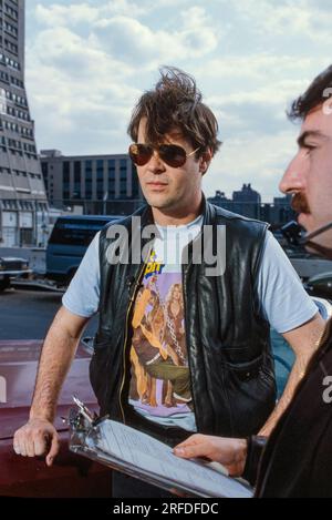 Kommedian/Schauspieler Dan Aykroyd am Drehort 1982. Bernard Gotfryd Foto. Daniel Edward Aykroyd ist ein kanadischer Schauspieler, Komiker, Drehbuchautor, Produzent und Musiker. Aykroyd war Autor und ursprüngliches Mitglied der „Not Ready for Prime Time Players“-Besetzung der NBC-Sketch-Comedy-Serie Saturday Night Live von ihrer Gründung im Jahr 1975 bis zu seiner Abreise im Jahr 1979. Während seiner Amtszeit bei SNL erschien er in einer wiederkehrenden Reihe von Skizzen, insbesondere zu den Coneheads und den Blues Brothers. Stockfoto