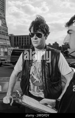 Kommedian/Schauspieler Dan Aykroyd am Drehort 1982. Bernard Gotfryd Foto. Daniel Edward Aykroyd ist ein kanadischer Schauspieler, Komiker, Drehbuchautor, Produzent und Musiker. Aykroyd war Autor und ursprüngliches Mitglied der „Not Ready for Prime Time Players“-Besetzung der NBC-Sketch-Comedy-Serie Saturday Night Live von ihrer Gründung im Jahr 1975 bis zu seiner Abreise im Jahr 1979. Während seiner Amtszeit bei SNL erschien er in einer wiederkehrenden Reihe von Skizzen, insbesondere zu den Coneheads und den Blues Brothers. Stockfoto