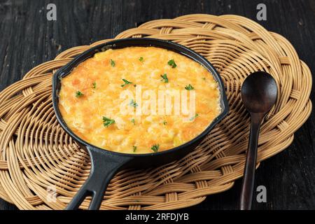 Koreanischer Maiskäse in einer Bratpfanne aus Gusseisen auf einem Holztisch Stockfoto