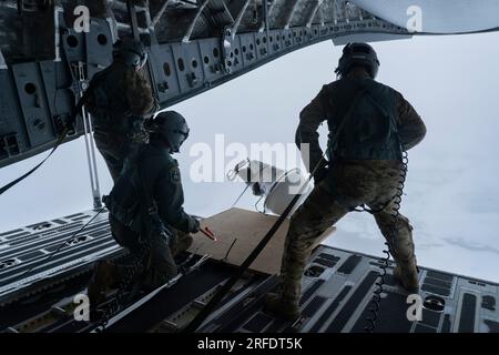 Von links nach rechts: Alaska Air National Guard Senior Master Sgt. Brian Johnson, Tech. Sgt. Chris Eggleston und Senior Master Sgt. Cecil Dickerson, Ladungsführer der 144. Luftschleuse auf der Basis Elmendorf-Richardson, bereiten sich auf den Einsatz einer ICEX-LUFTBOJE während einer Abwurfmission über dem Arktischen Ozean vor, am 12. Juli 2023. Das Office of Naval Research hat sich mit dem 144. ZUSAMMENGETAN, um fünf verschiedene Arten von Datenerfassungsbojen über mehr als 1.000 Seemeilen des Arktischen Ozeans zu verteilen. (USA Air Force Foto von Airman 1. Class Shelimar Rivera Rosado) Stockfoto