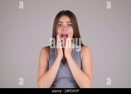 Nahaufnahme einer beeindruckten Frau, isoliert über Studiohintergrund. Porträt eines aufgeregten jungen Mädchens, das in Aufregung schaut. Junge Frau schockiert von "s" Stockfoto