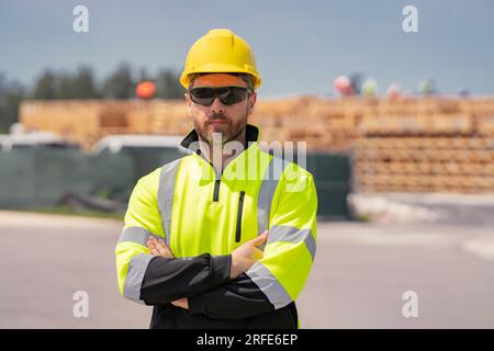 Bauarbeiter mit Schutzhelm auf amerikanischer Baustelle. Bauingenieurarbeiter in Baukleidung auf der Baustelle. Porträt von Bu Stockfoto