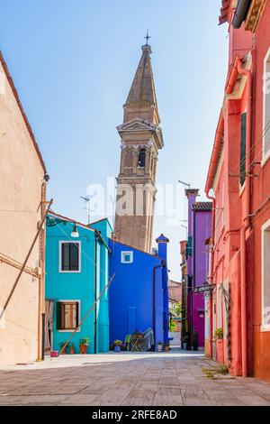 Farbenfrohe Häuser entlang des Wasserkanals mit dem schiefen Glockenturm in der Nähe der Kirche St. Martin Bishop auf der Insel Burano, Venedig. Stockfoto