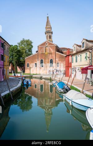 Farbenfrohe Häuser entlang des Wasserkanals mit dem schiefen Glockenturm in der Nähe der Kirche St. Martin Bishop auf der Insel Burano, Venedig. Stockfoto