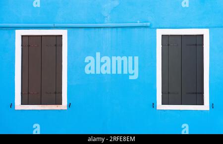 Details mit bunten Fenstern mit blau bemalten Wänden und Holzläden in Burano, Italien. Stockfoto