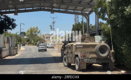 Eine israelische Militärwagenpatrouille am Eingang des israelisch annektierten alawisch-arabischen Dorfes Ghajar, ebenfalls Rhadjar, das an der Grenze zum Libanon liegt, und des israelisch besetzten Teils der syrischen Golanhöhen am 2. August 2023 in Ghajar, Israel Stockfoto