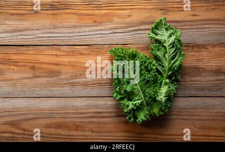 Grünkohl auf einem Holzhintergrund. Grünkohl. Blick von oben. Stockfoto