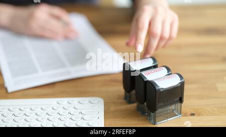 Drei Stempel genehmigt, abgesagt auf einem Schreibtisch für Geschäftsfrau Stockfoto