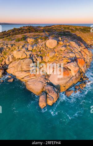 Luftaufnahme auf eine felsige Küsteninsel mit Flechten überzogenen Felsbrocken im Victor Harbor in Südaustralien Stockfoto