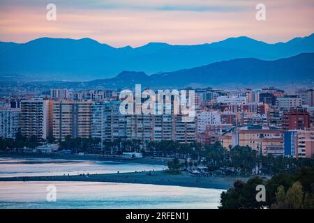 Malaga Stadtstrand, Wohngebäude Sonnenuntergang über den Bergen Stockfoto