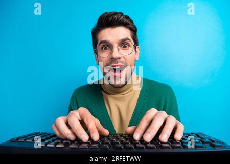 Großaufnahme eines jungen überraschten Werbetexters mit einer Nachricht des ceo seiner Firma, die auf zyanfarbenem Hintergrund isoliert wird Stockfoto