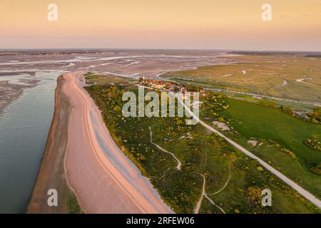 Frankreich, Somme, Baie de Somme, Le Hourdel, soleil couchant sur le Hourdel à l'extrémité du cordon de galets alors que la Marée basse dévoile les méandres des chenaux et les reliefs des Bancs de Sable (vue aérienne) Stockfoto