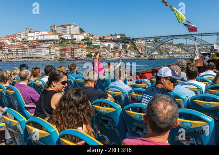 Porto, Portugal. Besucher, die eine Besichtigungstour auf einem Tourboot auf dem Douro River genießen. Sie nähern sich der Brücke Dom Luis I. Stockfoto