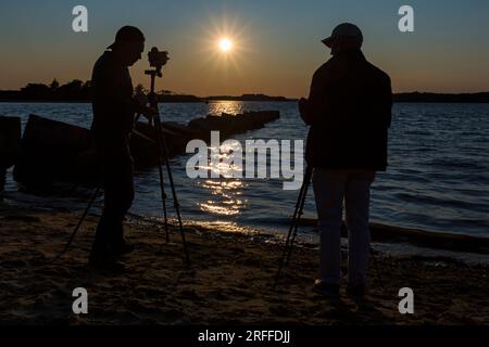 Fotografen, die Stative benutzen und bei Sonnenuntergang im Juli Dragons Teeth fotografieren, stellen im Zweiten Weltkrieg Panzerfallen der Verteidigungsblöcke dar Stockfoto