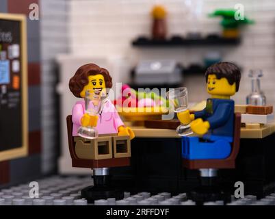 Tambov, Russische Föderation - 22. Juni 2023 Lego-Paar-Minifiguren, die hinter dem Tisch sitzen und zu Hause Wein trinken Stockfoto
