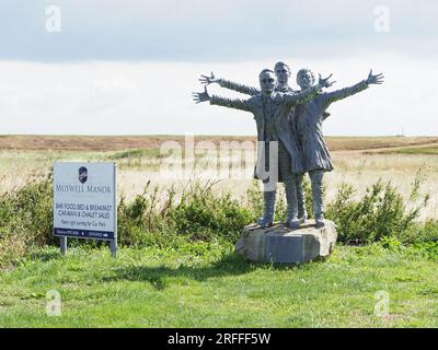 Leysdown, Kent, Großbritannien. 3. Aug. 2023. Muswell Manor (auch bekannt als Mussel Manor) in Leysdown war die Isle of Sheppey der weltweit erste Aeroklub und ist mit einem Orientierungspreis von 850k £ für das Clubhaus zu verkaufen, oder £1,8 Millionen €, wenn sie mit dem kleinen Urlaubspark um das Clubhaus herum gekauft wurde. JTC Moore Brabazon nahm den ersten britischen Motorflug auf und wurde von den Gebrüdern Wright, Short Brothers, CS Rolls und anderen bemerkenswerten Pionieren der frühen Luftfahrt besucht. Bild: Eine Statue der kleinen Brüder (Oswald, Horace, Eustace). Kredit: James Bell/Alamy Live News Stockfoto