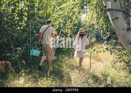 Pilzpflücker Dad mit seiner Tochter, die im Wald nach Pilzen suchen Stockfoto