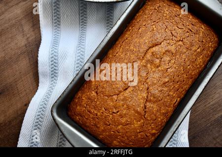 Frisch gebackener Laib mit gewürztem Kürbisbrot auf rustikalem Hintergrund Stockfoto